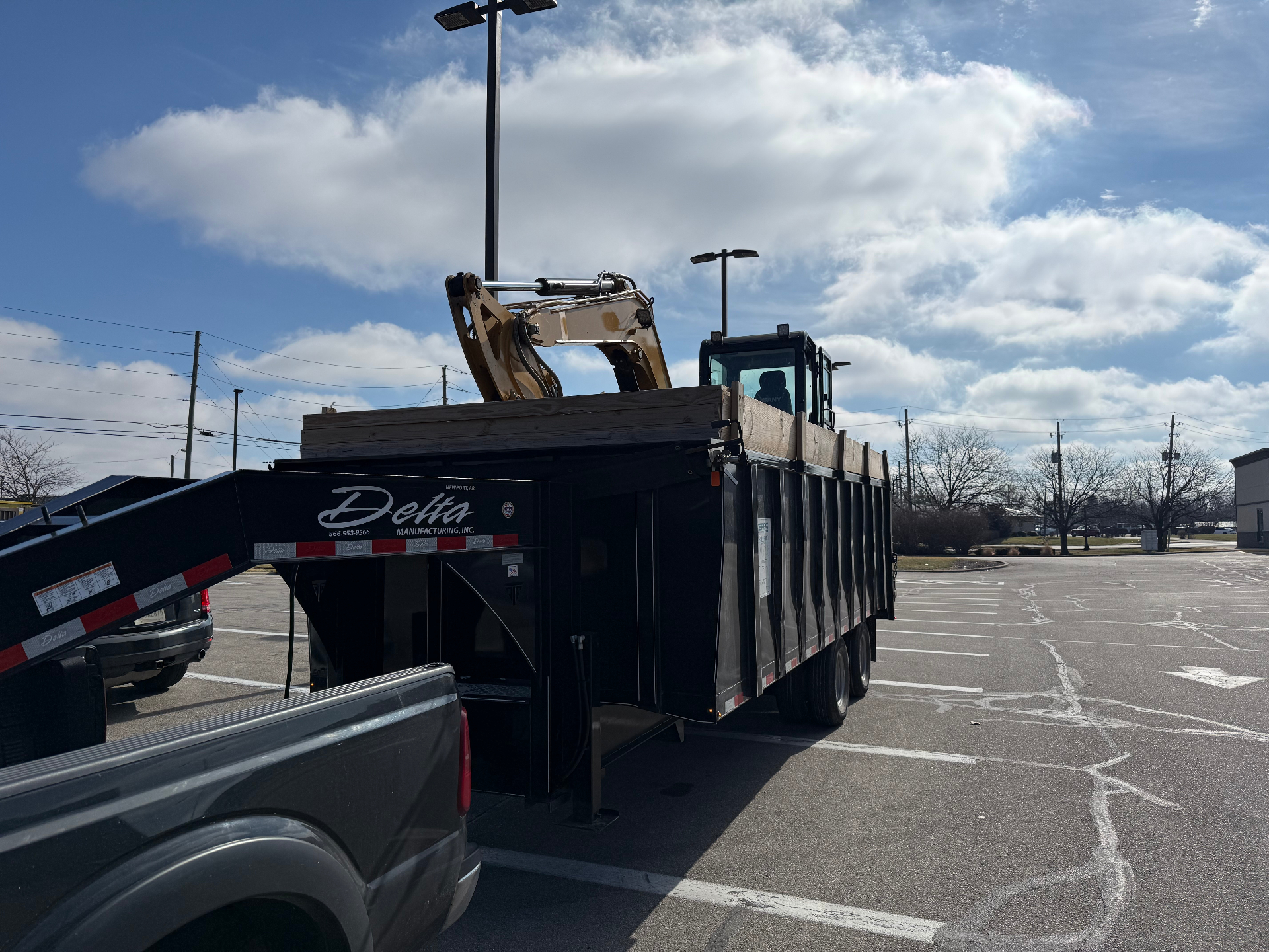 Delta gooseneck equipment trailer loaded with a mini excavator, ready to deliver to a Central Indiana jobsite